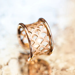 Une bague écaille dorée est posée sur un support de type marbre